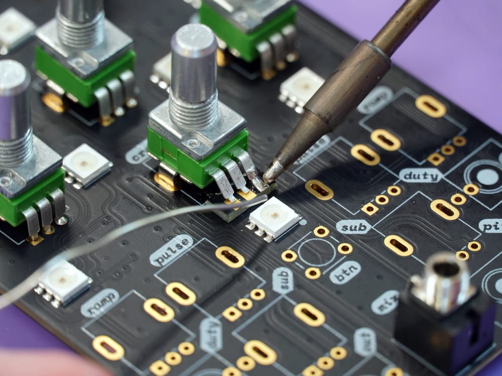 Technician soldering an electronics circuit board