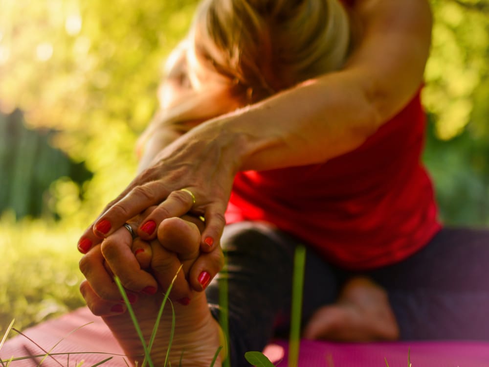 Woman stretching outdoors on a yoga mat