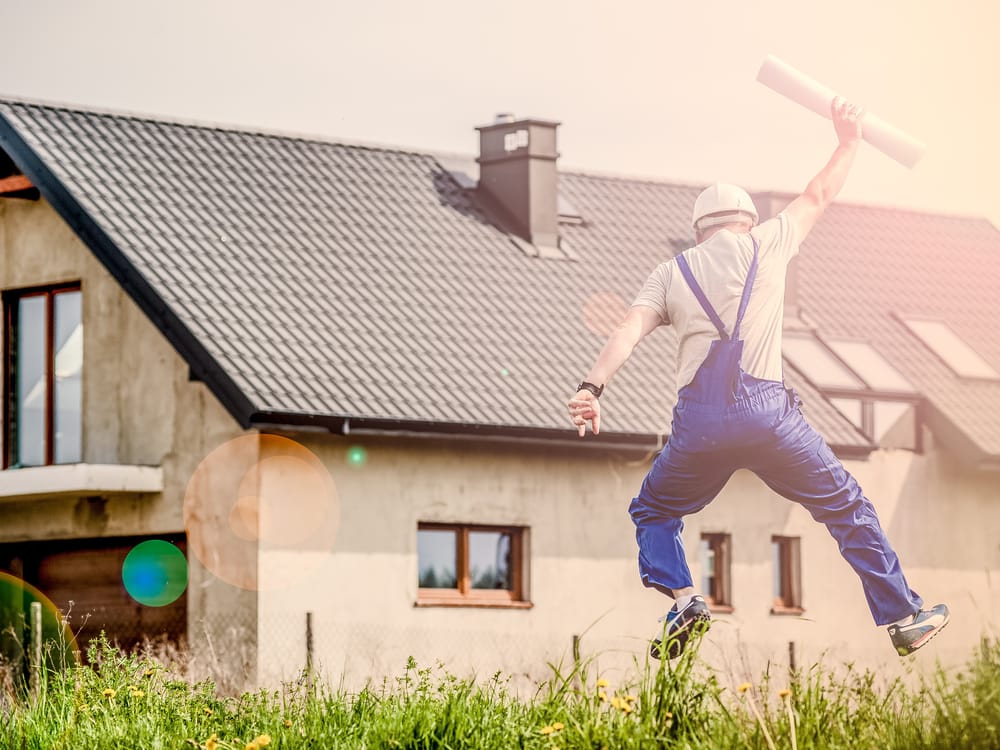 Contractor celebrating in front of a house under construction