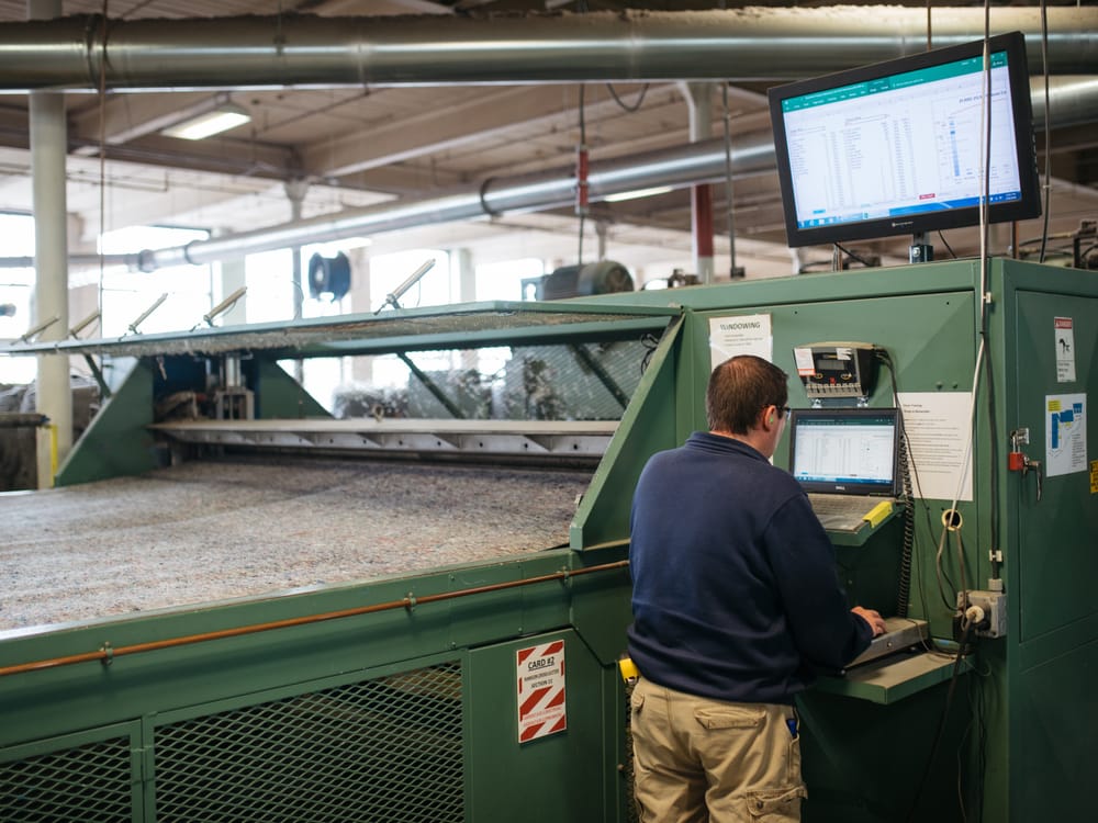 Worker monitoring a textile manufacturing line